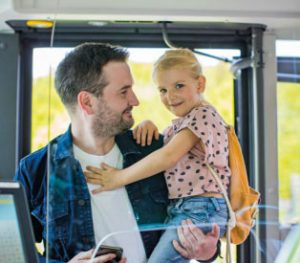Vater mit kleinen Tochter am Arm fährt mit dem Zug